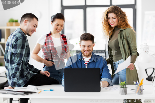 Image of creative team with laptop working at office