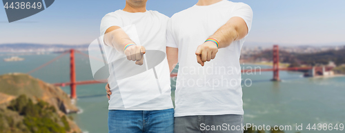 Image of couple with gay pride rainbow wristbands