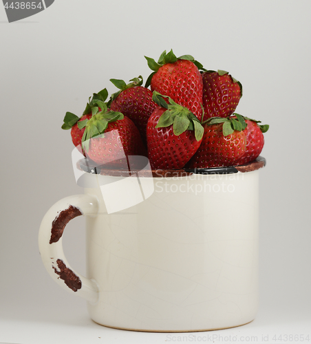 Image of strawberry in a mug on white