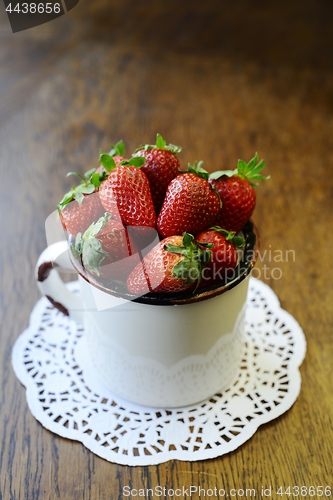 Image of strawberry in a mug on a wooden table