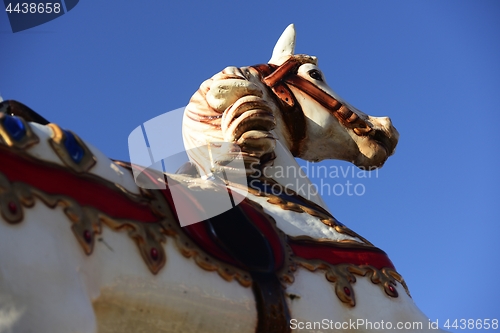 Image of carousel horse in an amusement park on a blue sky