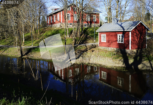 Image of typical finnish wooden houses on the river bank