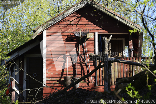 Image of red garden wooden  shed and tools