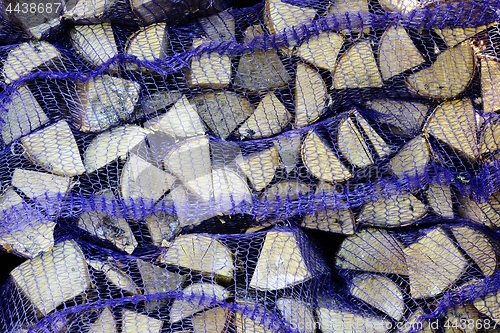 Image of birch firewood in nets in the clay