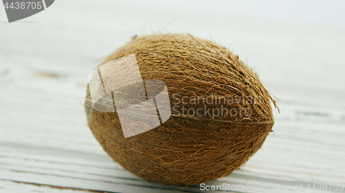 Image of Unpeeled brown coconut on table