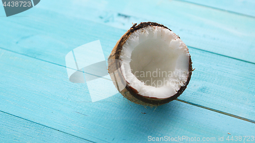 Image of Half coconut on blue table 