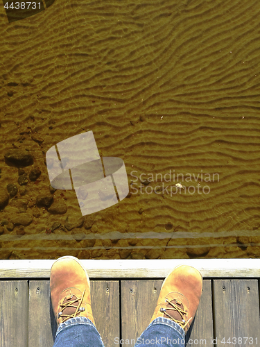 Image of feet in suede shoes on a dock