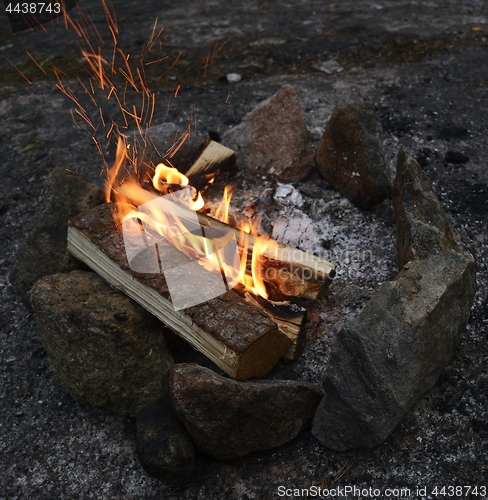 Image of bonfire burning on a rocky shore