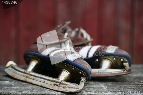 Image of vintage pair of mens  ice skates on the bench