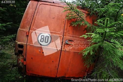 Image of abandoned orange car in the forest