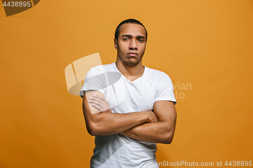 Image of The serious businessman standing and looking at camera against studio background.