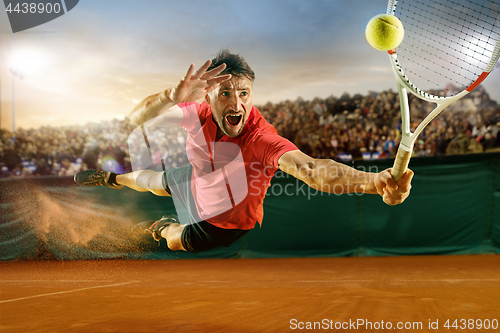 Image of The one jumping player, caucasian fit man, playing tennis on the earthen court with spectators