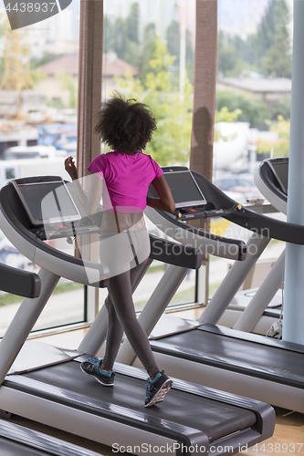 Image of afro american woman running on a treadmill