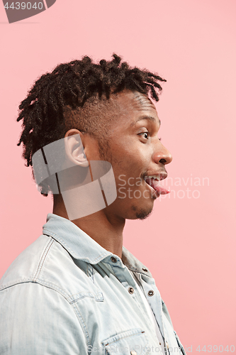 Image of The crazy business Afro-American man standing and wrinkle face pink background. Profile view.