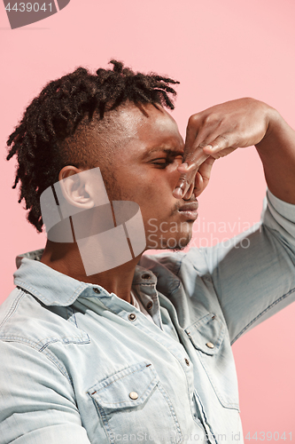 Image of Let me think. Doubtful pensive Afro-American man with thoughtful expression making choice against pink background