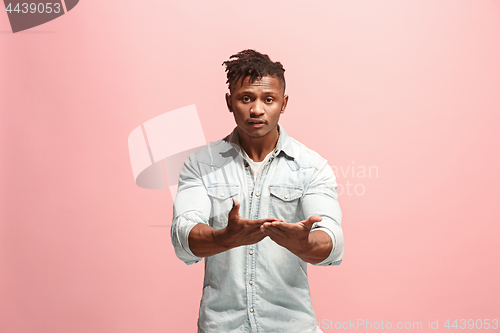 Image of Beautiful male half-length portrait isolated on pink studio backgroud. The young emotional surprised man