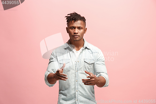 Image of Beautiful male half-length portrait isolated on pink studio backgroud. The young emotional surprised man