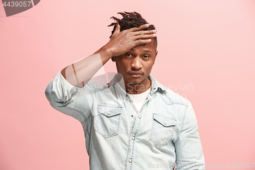 Image of African American Man having headache. Isolated over pink background.