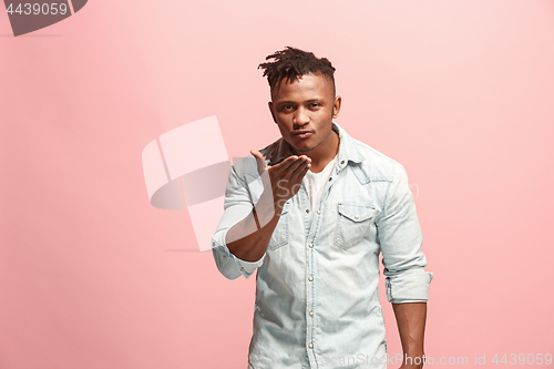 Image of Portrait of attractive Afro-American man with air kiss isolated over pink background