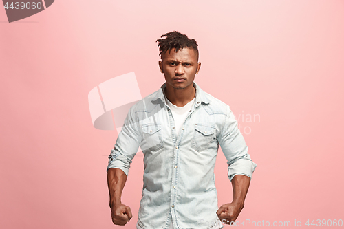 Image of The young emotional angry afro man screaming on pink studio background