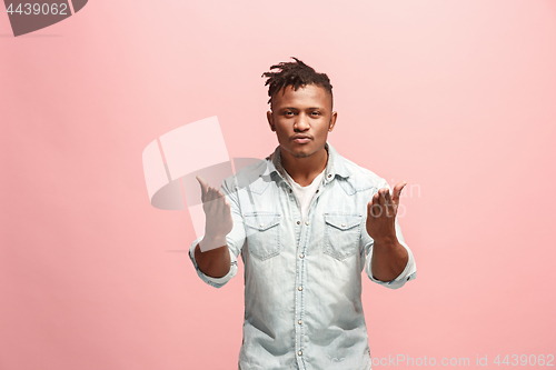 Image of Beautiful male half-length portrait isolated on pink studio backgroud. The young emotional surprised man