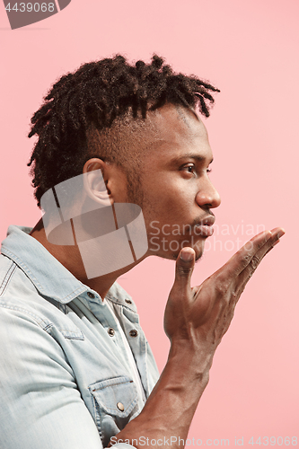 Image of Portrait of attractive Afro-American man with air kiss isolated over pink background