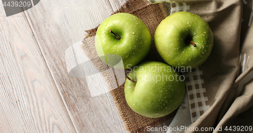 Image of Wet green apples on canvas