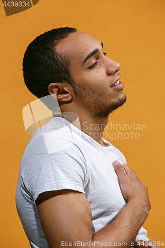 Image of Satisfy Afro-American man is smiling against orange background
