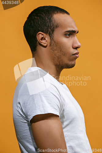 Image of Serious Afro-American man is looking serious against orange background