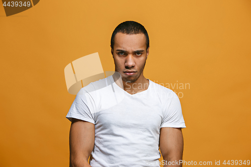 Image of The serious businessman standing and looking at camera against studio background.