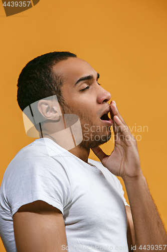 Image of Bored Afro-American man want to sleep against orange background