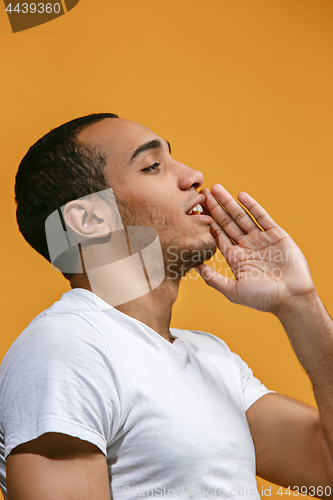 Image of Happy Afro-American man is shouting against orange background