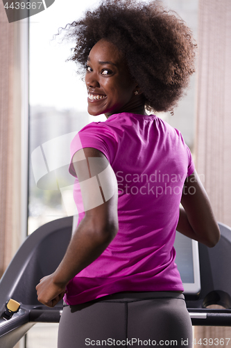 Image of afro american woman running on a treadmill