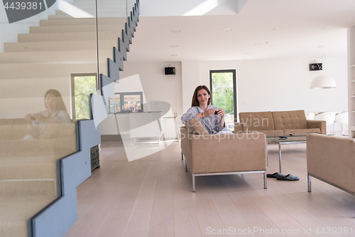 Image of young woman in a bathrobe enjoying morning coffee