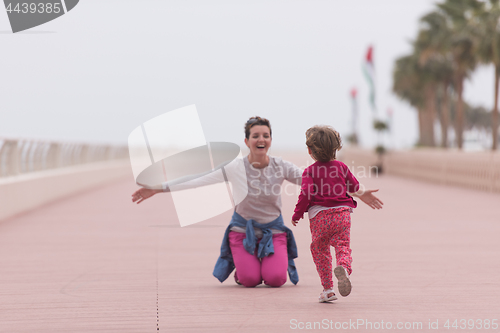 Image of mother and cute little girl on the promenade by the sea