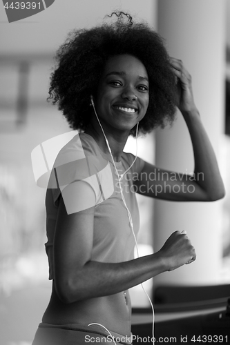 Image of afro american woman running on a treadmill