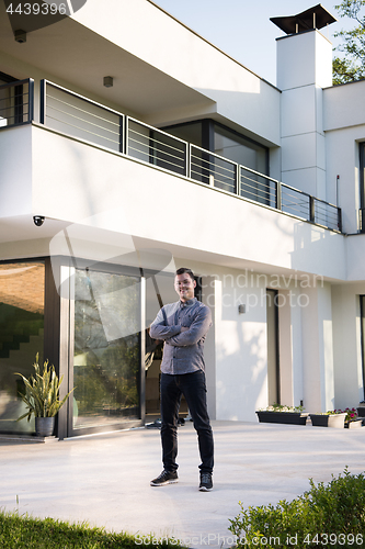 Image of man in front of his luxury home villa