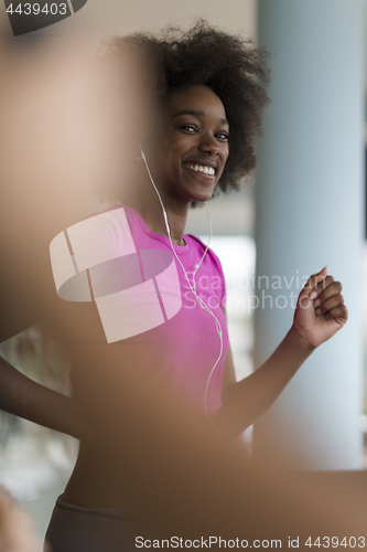 Image of afro american woman running on a treadmill