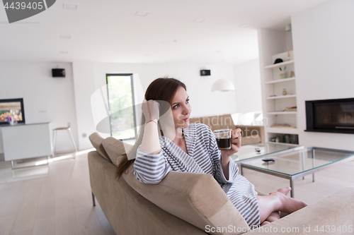 Image of young woman in a bathrobe enjoying morning coffee