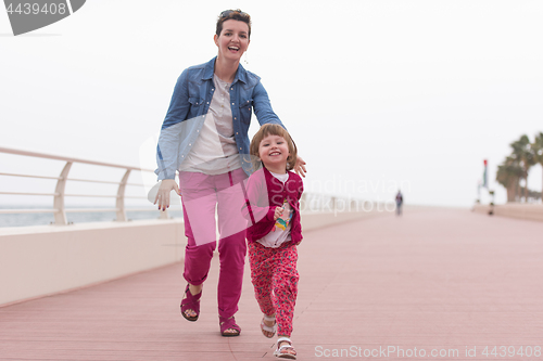 Image of mother and cute little girl on the promenade by the sea