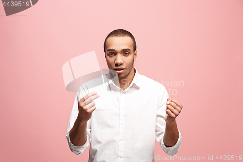 Image of Beautiful male half-length portrait isolated on pink studio backgroud. The young emotional surprised man