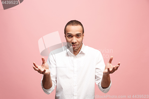 Image of Beautiful male half-length portrait isolated on pink studio backgroud. The young emotional surprised man