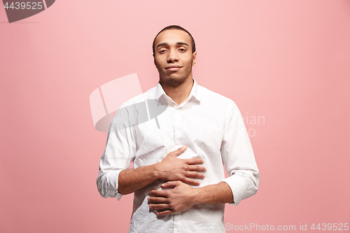 Image of The happy business man standing and smiling against pink background.