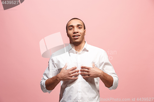 Image of The happy business man standing and smiling against pink background.