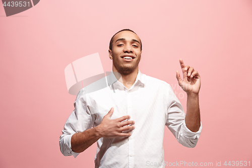 Image of The happy business man standing and smiling against pink background.