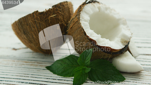 Image of Halves of fresh coconut with mint leaves