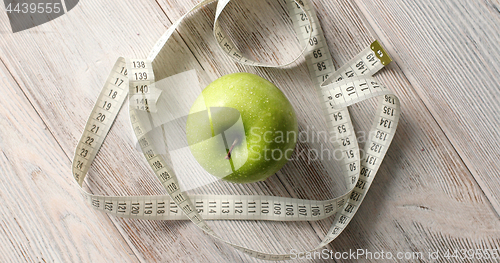 Image of Green apple and measuring tape on table