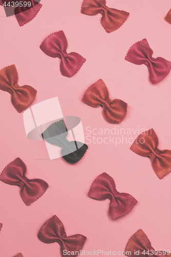 Image of Pink and black pasta farfalle lies diagonally