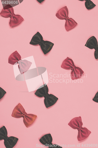 Image of Pink and black pasta farfalle lies diagonally