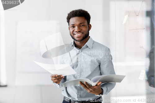 Image of african american businessman with folder at office